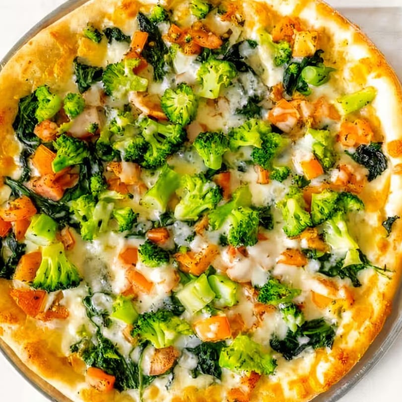Tuscan Bistro's white pizza with broccoli, spinach, and chicken on a golden crust.
